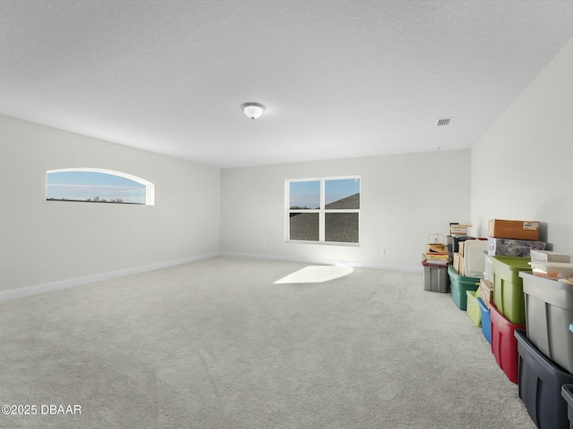 playroom featuring light colored carpet and a textured ceiling