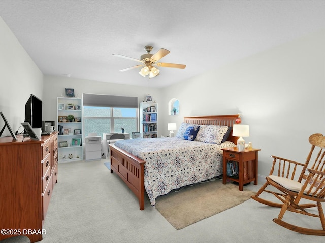 carpeted bedroom with a textured ceiling and ceiling fan