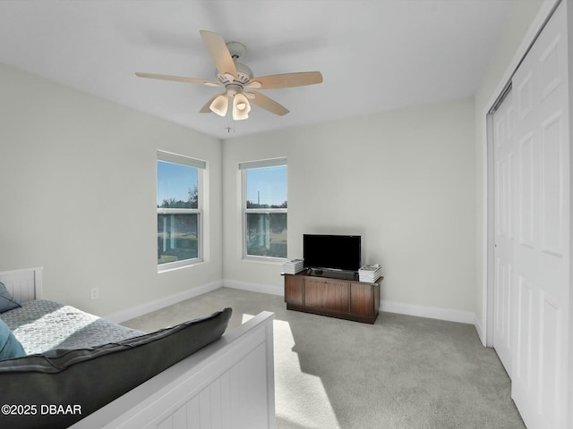 bedroom featuring ceiling fan, a closet, and light carpet