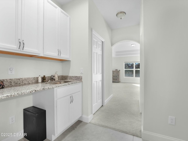 corridor featuring sink and light colored carpet