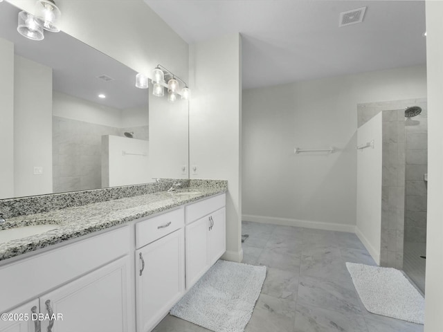 bathroom with vanity and tiled shower