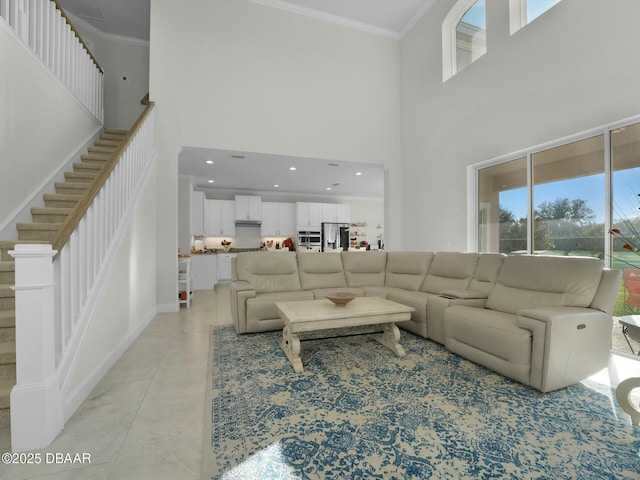 tiled living room with ornamental molding and a high ceiling