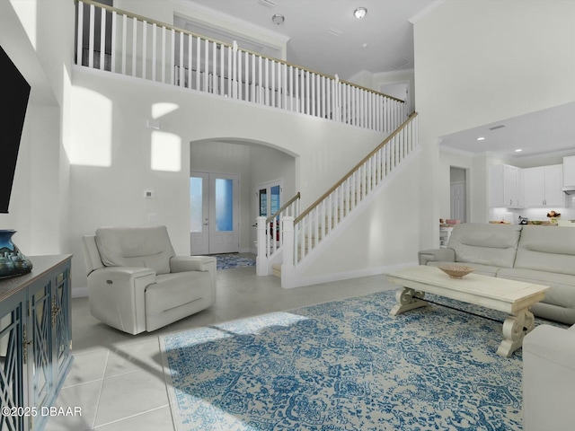 living room featuring crown molding, french doors, and a high ceiling