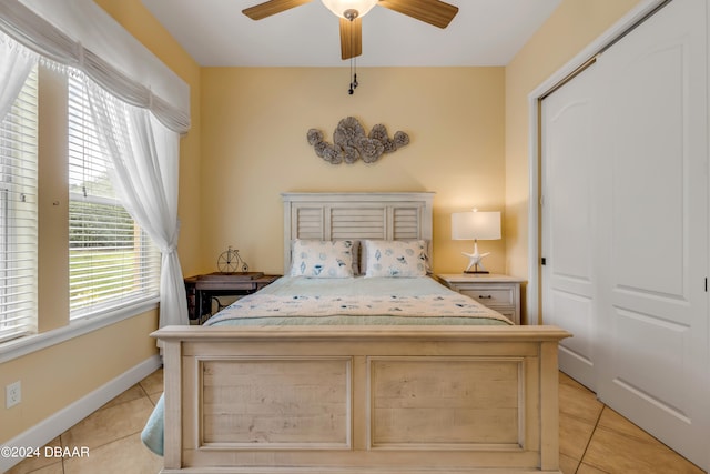 bedroom featuring light tile patterned floors, ceiling fan, and a closet