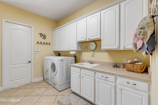 laundry area featuring cabinets, light tile patterned floors, sink, and washing machine and clothes dryer