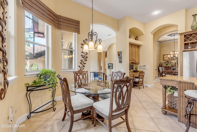 tiled dining room featuring an inviting chandelier