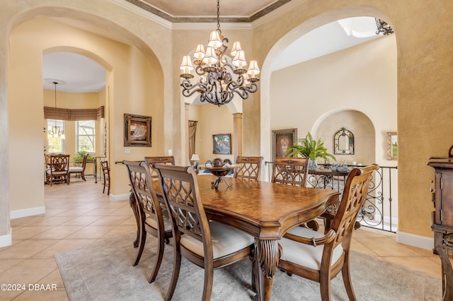 dining area featuring a chandelier, a towering ceiling, light tile patterned floors, and crown molding