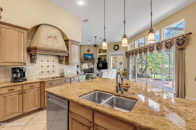 kitchen featuring sink, custom range hood, light tile patterned floors, hanging light fixtures, and black electric stovetop