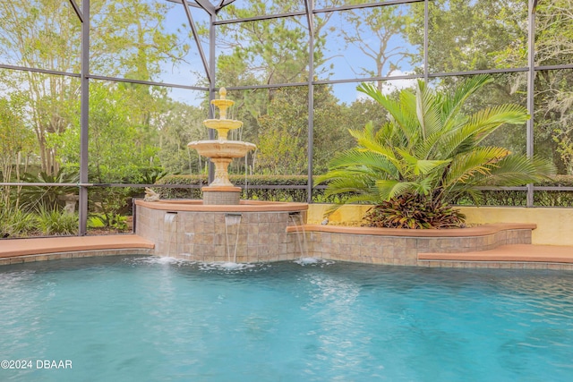 view of pool featuring glass enclosure and pool water feature