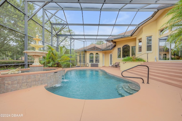 view of pool with glass enclosure, a patio, and pool water feature