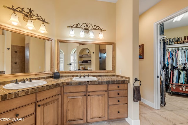 bathroom featuring tile patterned flooring, vanity, and a shower