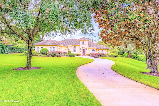 mediterranean / spanish home with a front lawn