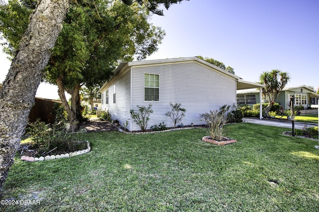 view of side of home featuring a carport and a lawn