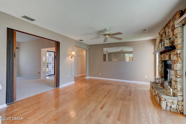 130 Kimberly Dr, Ormond Beach, FL 32174 - unfurnished living room with a ceiling fan, wood finished floors, a fireplace, a textured ceiling, and baseboards