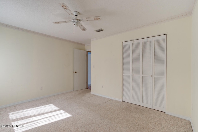 130 Kimberly Dr, Ormond Beach, FL 32174 - unfurnished bedroom featuring carpet flooring, a closet, ornamental molding, a ceiling fan, and baseboards