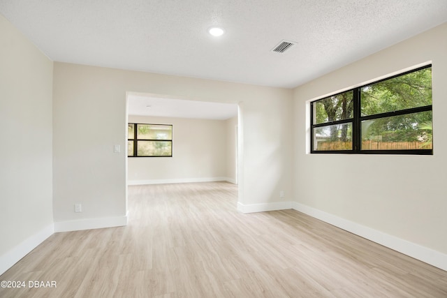 1512 Old Kings Rd, Daytona Beach, FL 32117 - spare room with light hardwood / wood-style flooring, a healthy amount of sunlight, and a textured ceiling