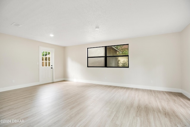 1512 Old Kings Rd, Daytona Beach, FL 32117 - spare room featuring a textured ceiling, light hardwood / wood-style flooring, and a wealth of natural light