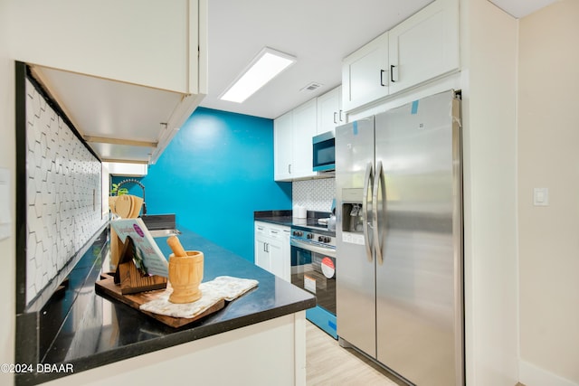 1512 Old Kings Rd, Daytona Beach, FL 32117 - kitchen featuring backsplash, stainless steel appliances, white cabinetry, and light hardwood / wood-style flooring