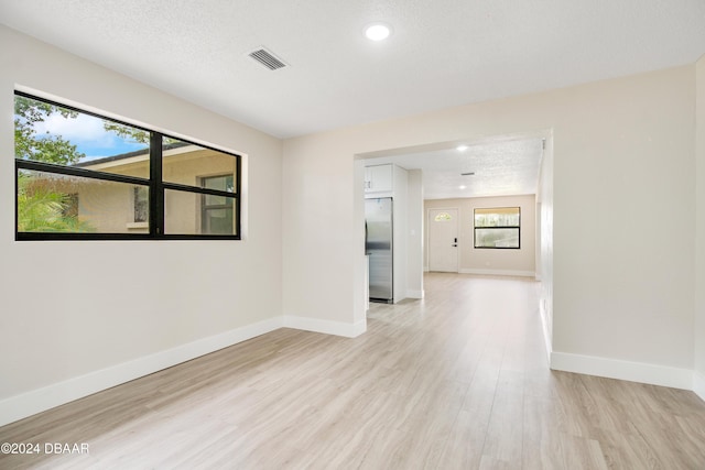 1512 Old Kings Rd, Daytona Beach, FL 32117 - spare room with a textured ceiling, light hardwood / wood-style flooring, and a wealth of natural light