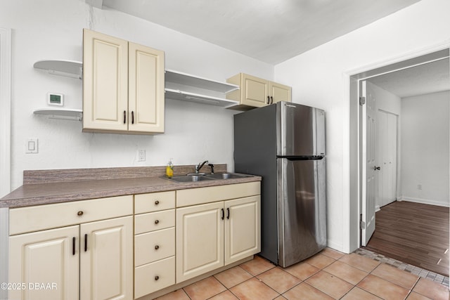 408 Frances Ter, Daytona Beach, FL 32118 - kitchen with open shelves, light tile patterned floors, dark countertops, freestanding refrigerator, and a sink
