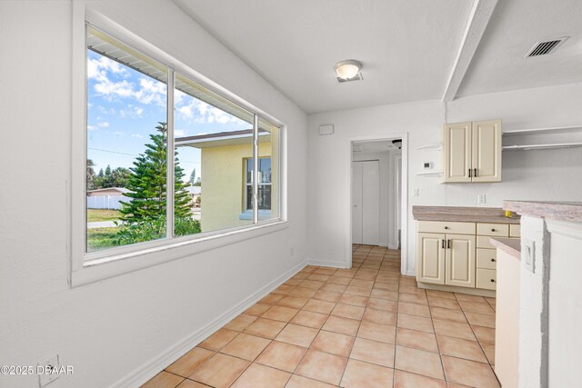 408 Frances Ter, Daytona Beach, FL 32118 - kitchen with visible vents, light countertops, cream cabinetry, a healthy amount of sunlight, and open shelves