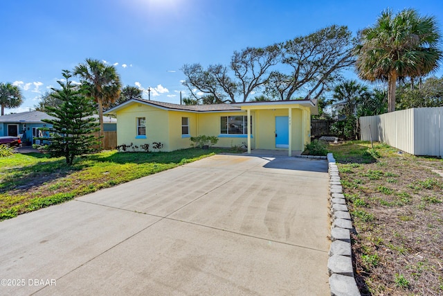 ranch-style home featuring a front yard, fence, and stucco siding