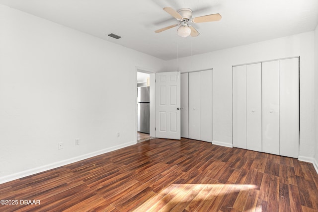 408 Frances Ter, Daytona Beach, FL 32118 - unfurnished bedroom featuring multiple closets, visible vents, dark wood-type flooring, freestanding refrigerator, and baseboards