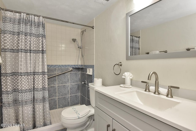 bathroom featuring walk in shower, vanity, and toilet