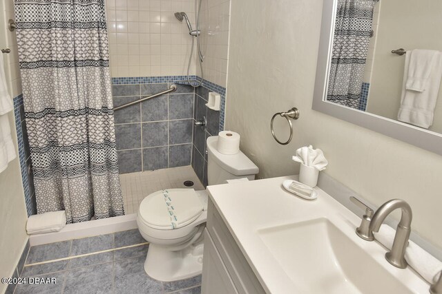 bathroom featuring walk in shower, tile patterned flooring, vanity, and toilet