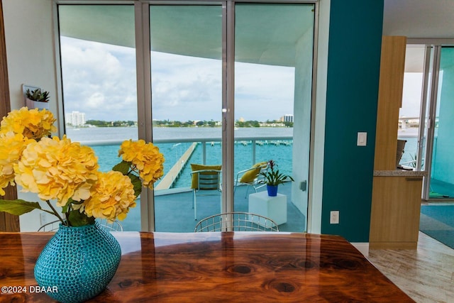 dining room with a water view, wood-type flooring, and plenty of natural light