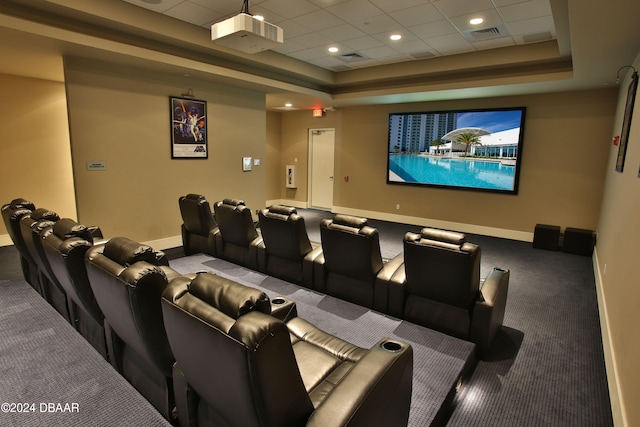 carpeted home theater room featuring a tray ceiling