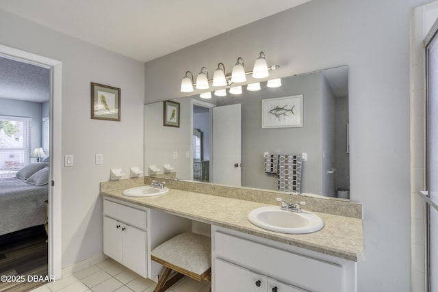 full bath with baseboards, double vanity, connected bathroom, and a sink