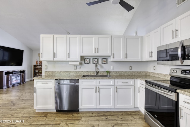 kitchen with a sink, stainless steel appliances, lofted ceiling, and visible vents