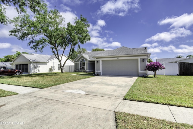 ranch-style house featuring a front lawn, fence, driveway, and an attached garage