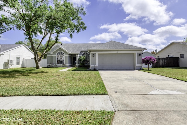 ranch-style home featuring a front lawn, fence, driveway, and an attached garage