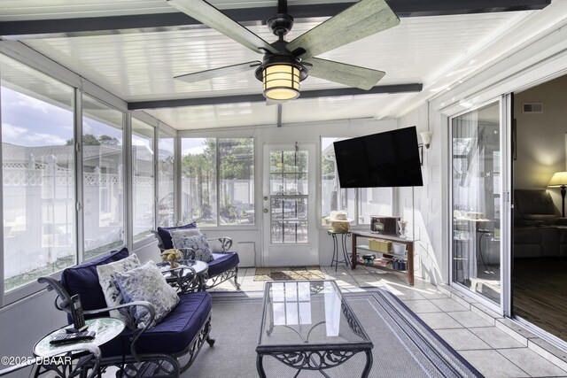 sunroom with ceiling fan, visible vents, tile patterned floors, and beamed ceiling