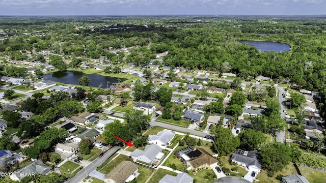 aerial view featuring a water view, a view of trees, and a residential view