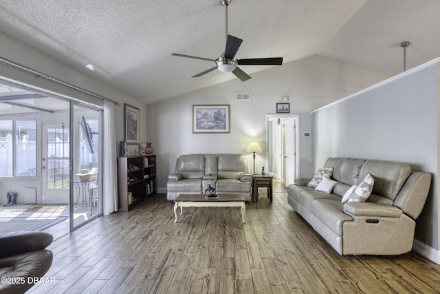 living room featuring a ceiling fan, wood finished floors, a textured ceiling, lofted ceiling, and visible vents