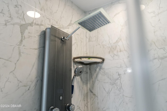 bathroom featuring a marble finish shower