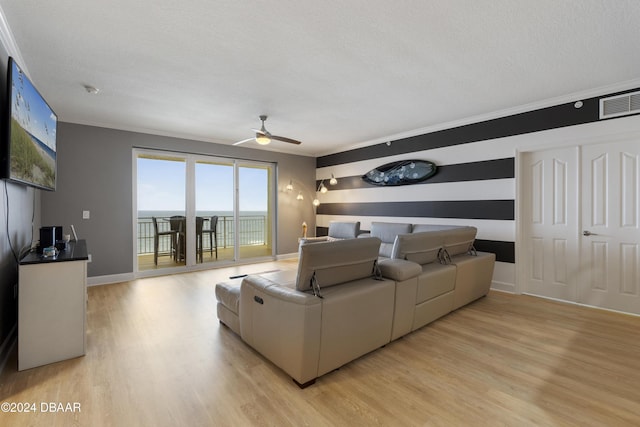 living area with light wood-style floors, visible vents, a textured ceiling, and a ceiling fan