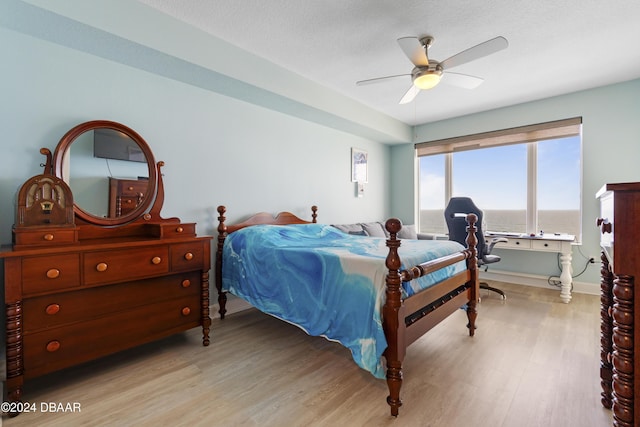 bedroom featuring light wood-style flooring, baseboards, and ceiling fan