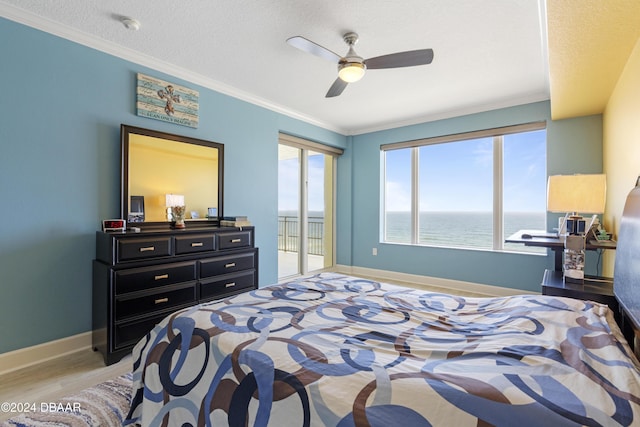 bedroom featuring baseboards, ornamental molding, light wood-type flooring, and access to exterior