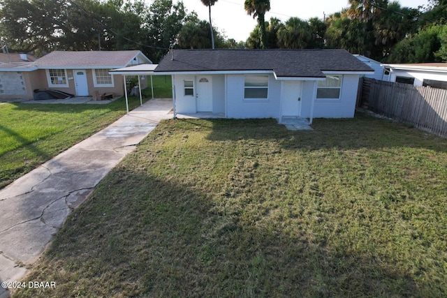 ranch-style house featuring a front lawn and a carport