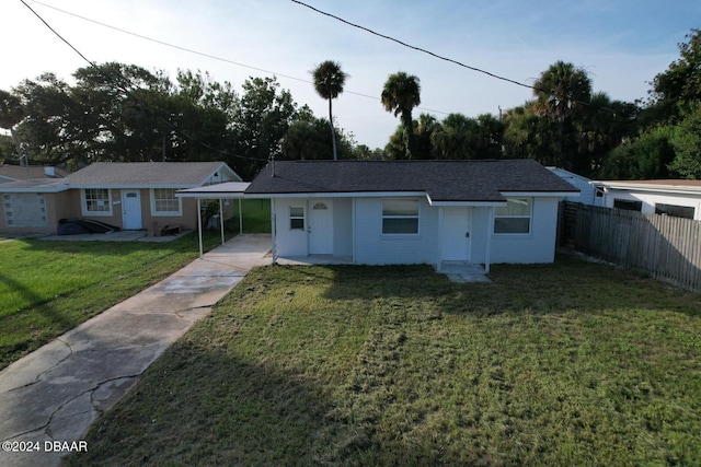 ranch-style house featuring a front lawn and a carport