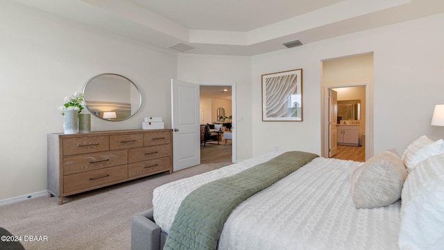 bedroom featuring ensuite bathroom and light colored carpet