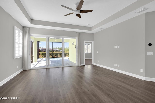 906 Coral Reef Way, Daytona Beach, FL 32124 - empty room with a ceiling fan, a tray ceiling, and dark wood-style flooring