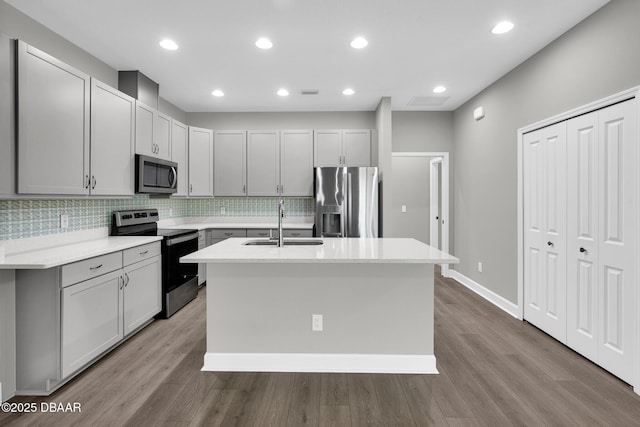 906 Coral Reef Way, Daytona Beach, FL 32124 - kitchen with appliances with stainless steel finishes, a kitchen island with sink, decorative backsplash, light countertops, and recessed lighting