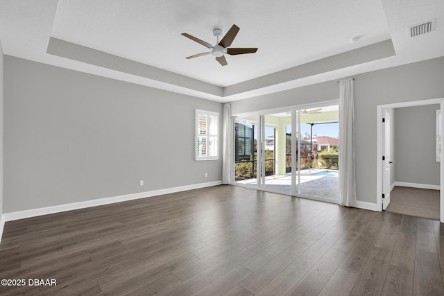 906 Coral Reef Way, Daytona Beach, FL 32124 - spare room featuring a raised ceiling, a ceiling fan, and dark wood-type flooring