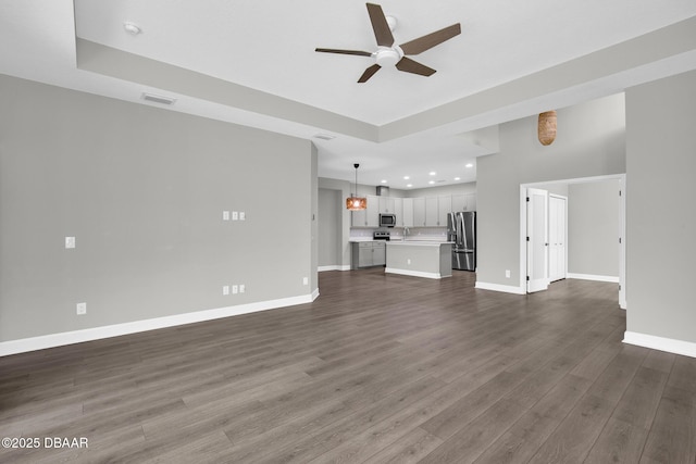 906 Coral Reef Way, Daytona Beach, FL 32124 - unfurnished living room featuring ceiling fan, recessed lighting, dark wood-type flooring, and a raised ceiling