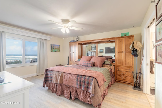 bedroom with light wood-type flooring, a ceiling fan, and baseboards